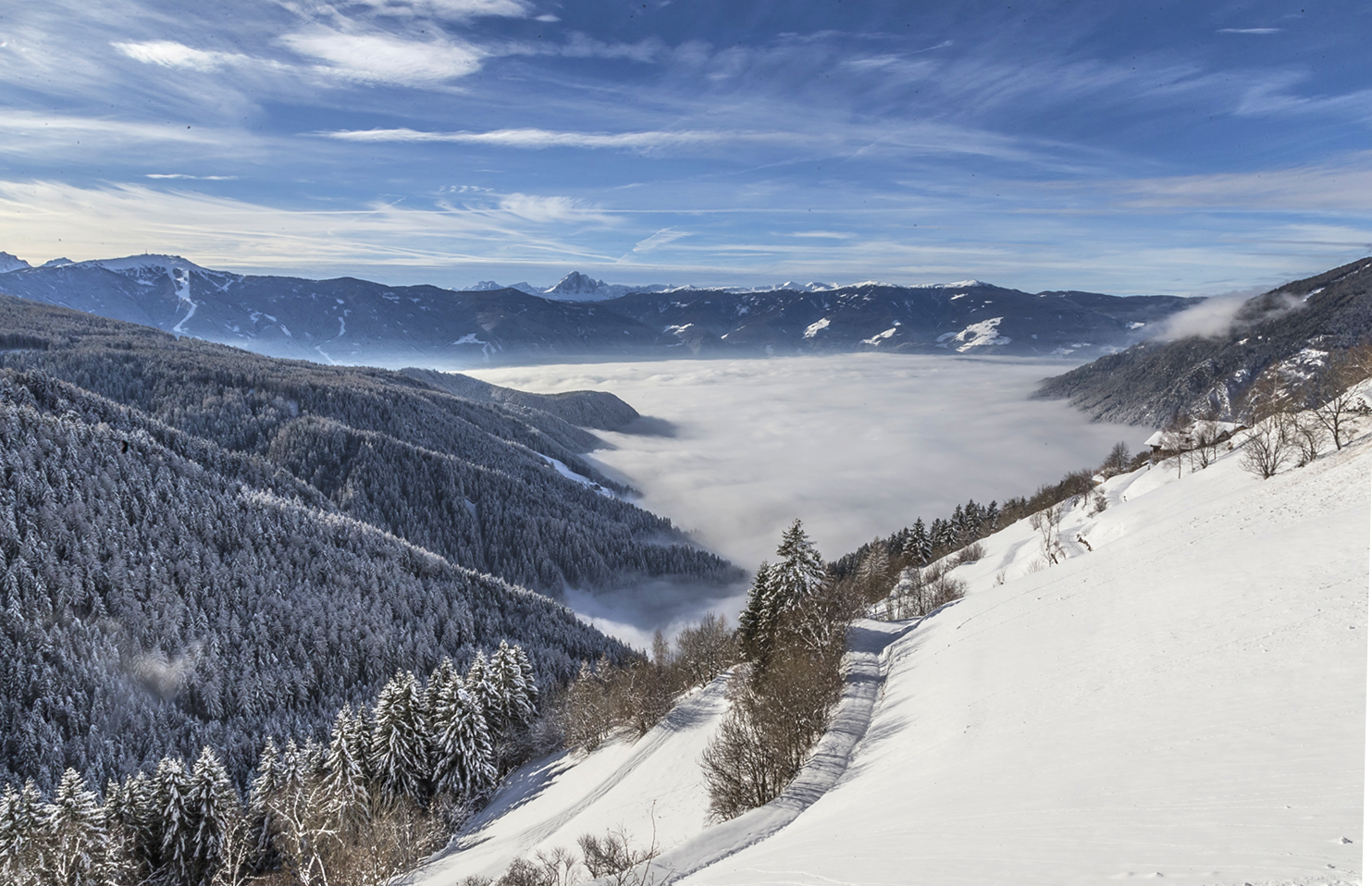 Verschneite Hänge bei Mühlbach mit Nebelmeer über dem Tal